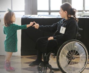 woman in wheelchair and young child speaking