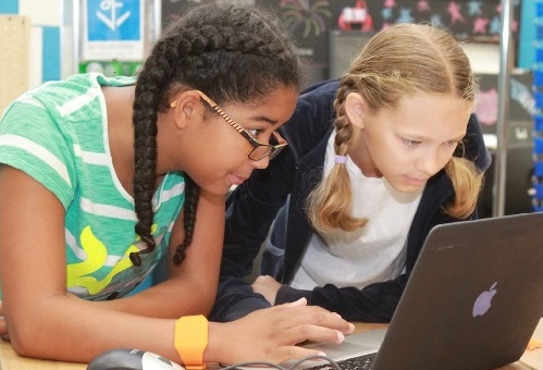 two female students working on a laptop computer